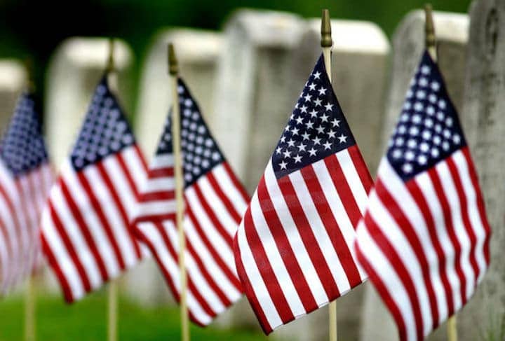 American flags next to veteran memorials